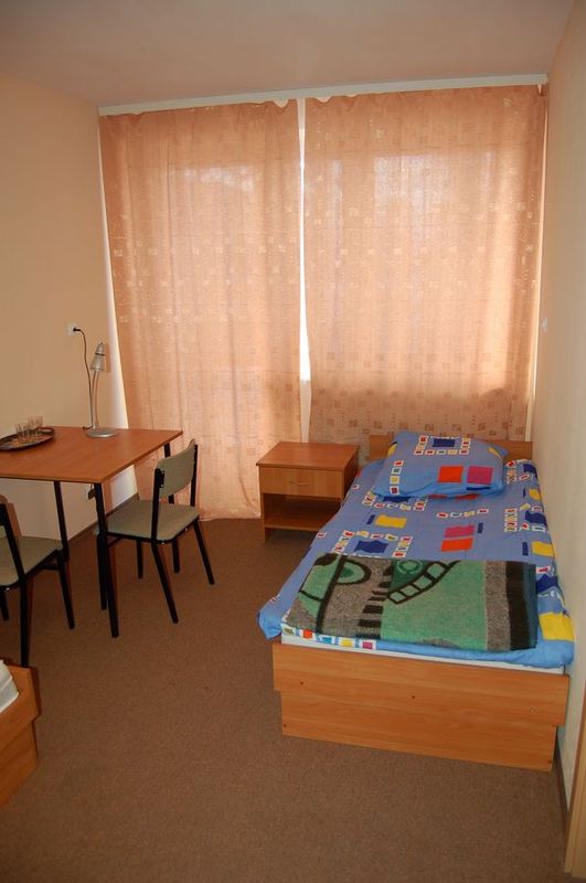 Wyposażenie pokoju: dwa łóżka, szafa, stół, krzesła, szafki